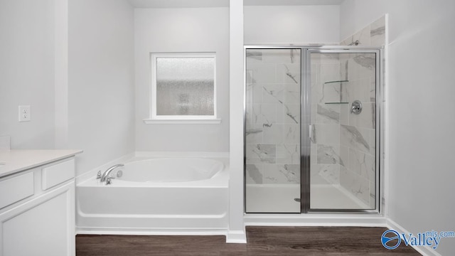 bathroom featuring plus walk in shower, hardwood / wood-style floors, and vanity