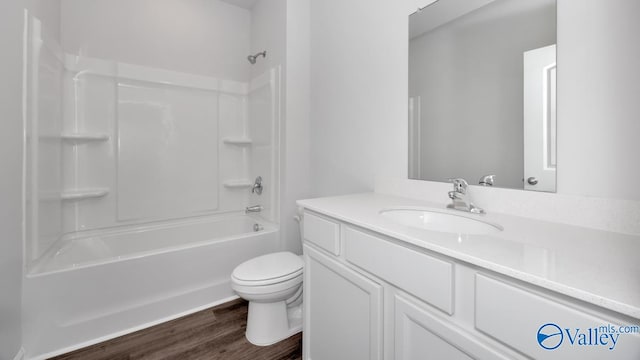 full bathroom featuring hardwood / wood-style floors, vanity, shower / bathtub combination, and toilet