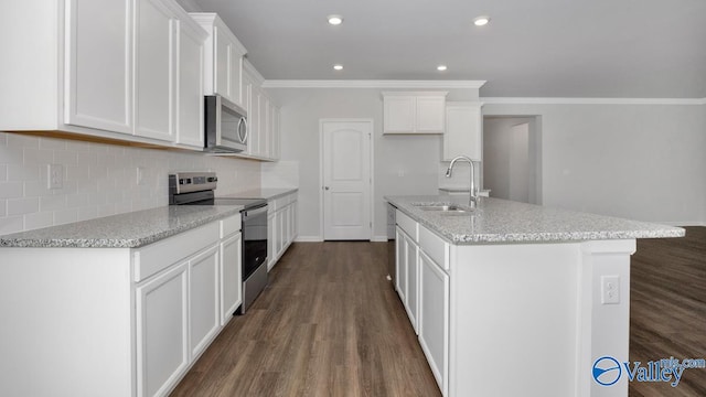 kitchen with stainless steel appliances, dark wood-type flooring, sink, a center island with sink, and white cabinets