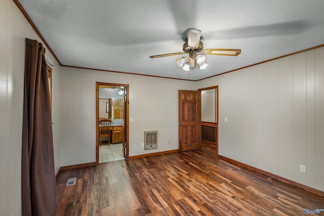 unfurnished bedroom with heating unit, ceiling fan, dark hardwood / wood-style flooring, a textured ceiling, and ensuite bathroom