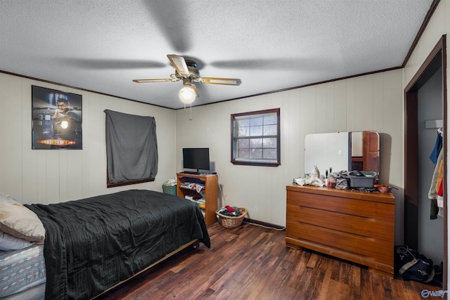 bedroom featuring dark wood-type flooring, ceiling fan, a textured ceiling, and ornamental molding