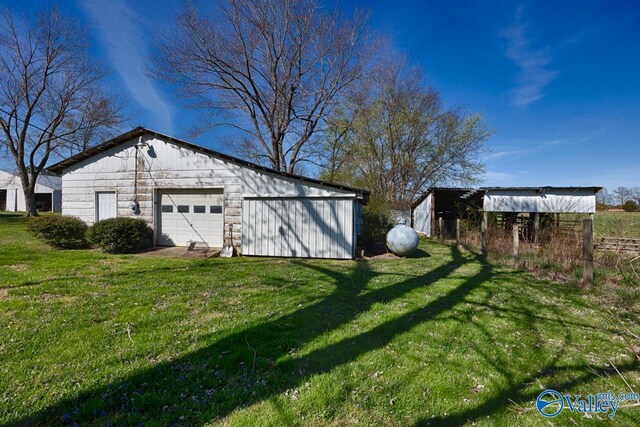 view of yard featuring a garage and an outbuilding