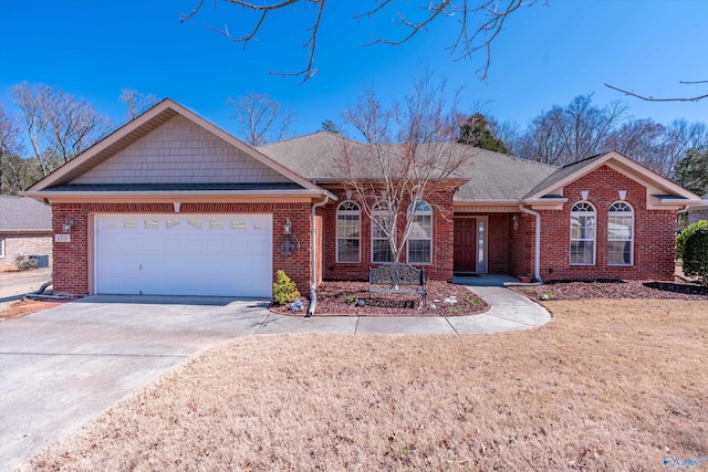 single story home with driveway, brick siding, and an attached garage