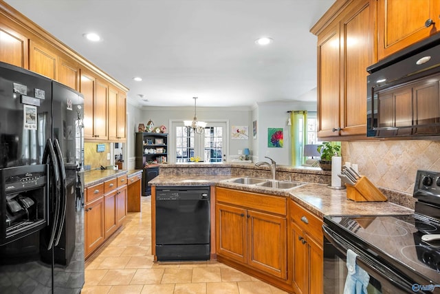 kitchen with black appliances, brown cabinetry, a peninsula, and a sink