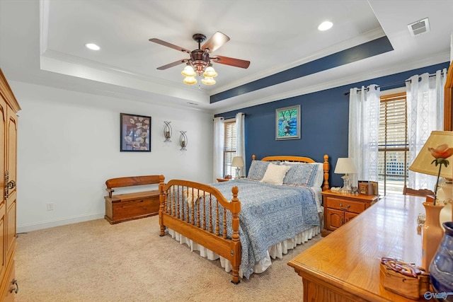 bedroom with a raised ceiling, light colored carpet, visible vents, ornamental molding, and baseboards