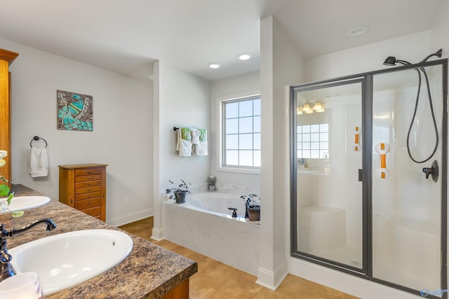 bathroom with double vanity, a garden tub, a sink, and a stall shower