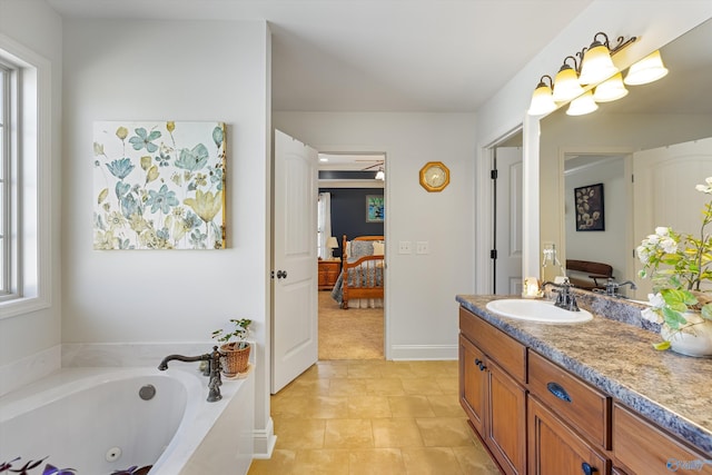 full bath featuring baseboards, connected bathroom, a whirlpool tub, tile patterned flooring, and vanity