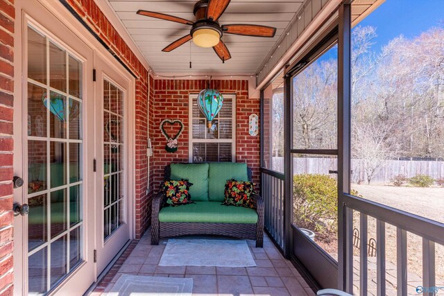 unfurnished sunroom featuring a ceiling fan