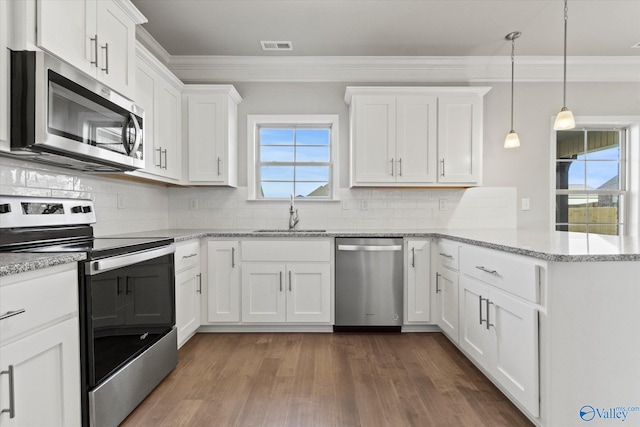 kitchen featuring sink, appliances with stainless steel finishes, white cabinetry, hanging light fixtures, and kitchen peninsula