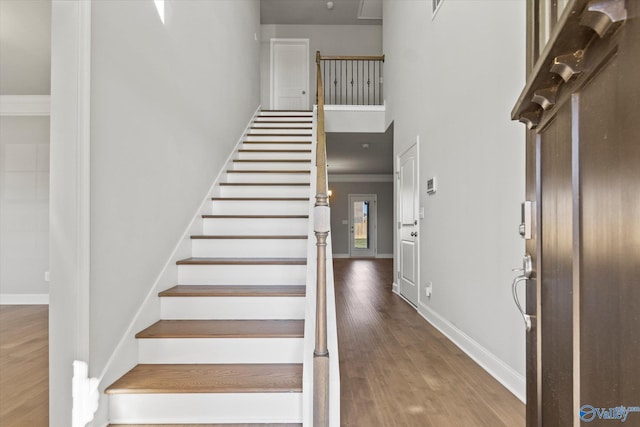 stairs featuring hardwood / wood-style flooring and crown molding