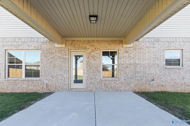 view of exterior entry with a patio area