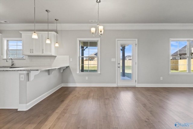 kitchen featuring white cabinetry, pendant lighting, backsplash, and a kitchen breakfast bar