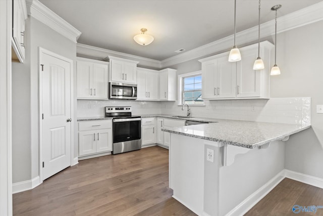 kitchen featuring stainless steel appliances, sink, white cabinets, and decorative light fixtures