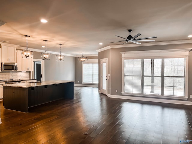 kitchen with white cabinetry, dark hardwood / wood-style flooring, light stone countertops, ceiling fan, and appliances with stainless steel finishes