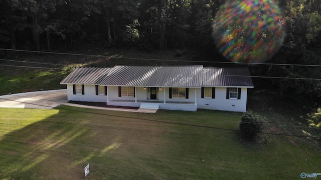 view of front of home with covered porch, a front yard, stucco siding, and metal roof