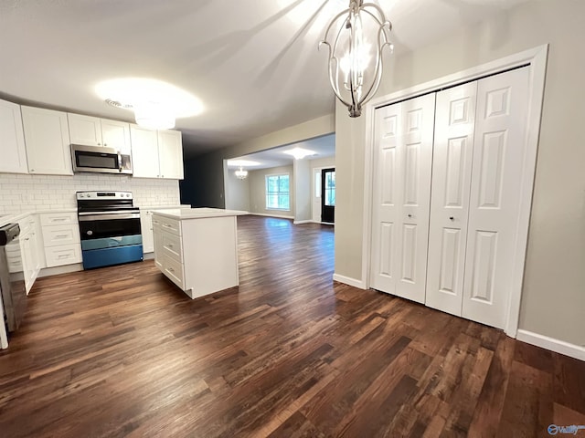 kitchen with an inviting chandelier, dark wood-style flooring, stainless steel appliances, and tasteful backsplash