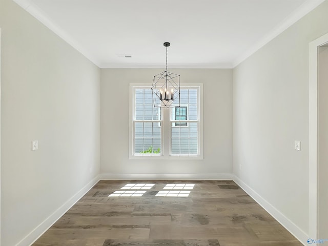 unfurnished room featuring crown molding, an inviting chandelier, and hardwood / wood-style flooring