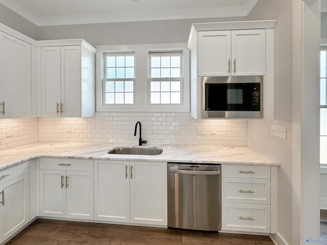 kitchen featuring built in microwave, sink, stainless steel dishwasher, and white cabinets