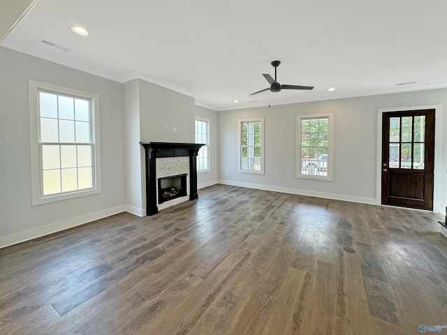 unfurnished living room featuring hardwood / wood-style floors, crown molding, a tile fireplace, and ceiling fan