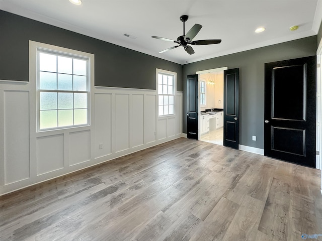 unfurnished bedroom with ceiling fan, connected bathroom, and light hardwood / wood-style flooring