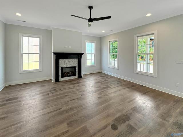 unfurnished living room with crown molding, ceiling fan, plenty of natural light, and dark hardwood / wood-style flooring