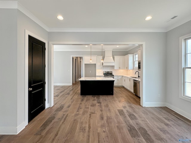 kitchen featuring sink, white cabinetry, a center island, appliances with stainless steel finishes, and custom range hood