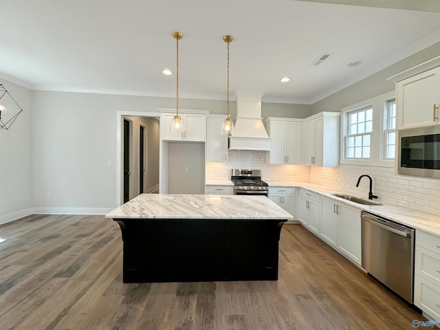 kitchen featuring sink, custom exhaust hood, a kitchen island, stainless steel appliances, and white cabinets