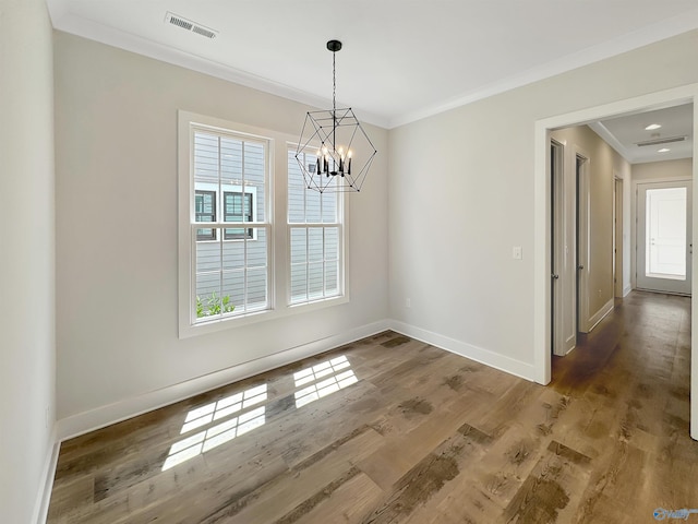 unfurnished dining area featuring an inviting chandelier, hardwood / wood-style floors, and ornamental molding