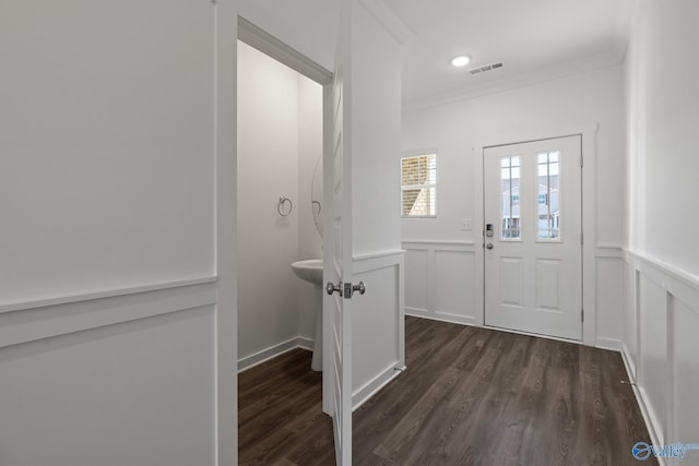 doorway featuring dark wood-type flooring and ornamental molding