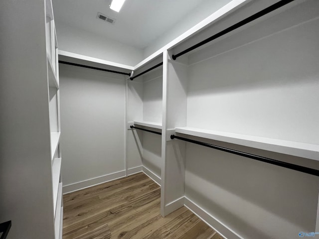 walk in closet with hardwood / wood-style floors