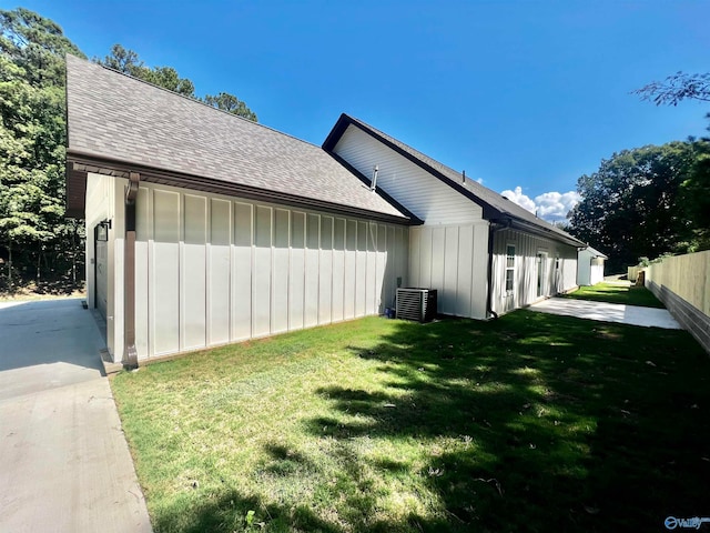 view of side of home featuring a lawn and cooling unit