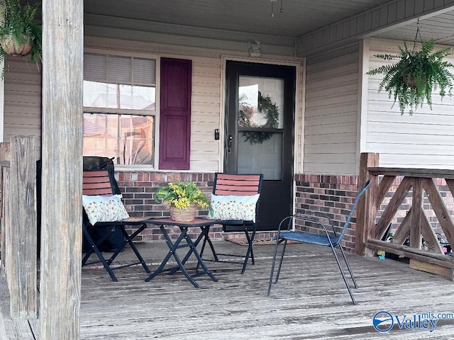 entrance to property featuring brick siding and a porch