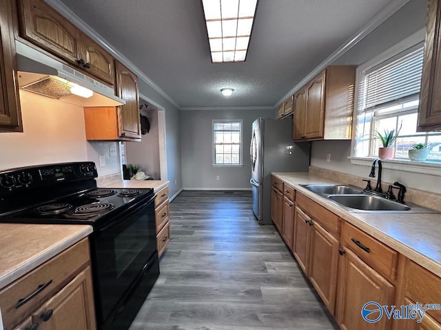 kitchen featuring crown molding, under cabinet range hood, dark wood finished floors, black / electric stove, and a sink