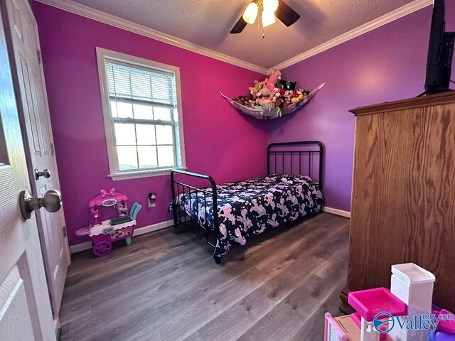 bedroom with baseboards, wood finished floors, a textured ceiling, and ornamental molding