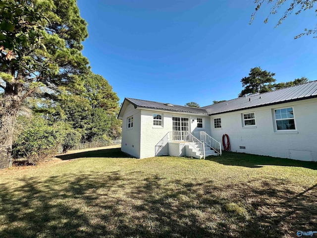 rear view of house featuring a yard