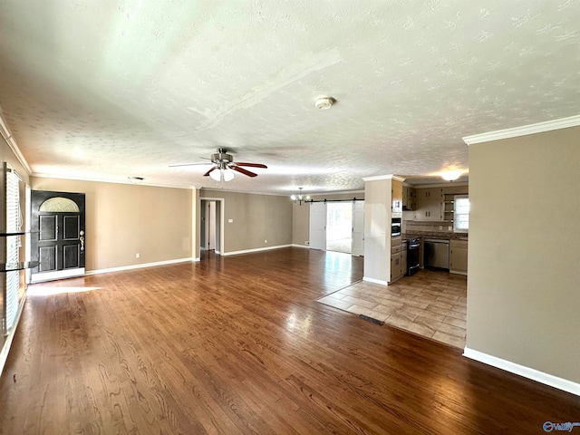 unfurnished living room featuring hardwood / wood-style floors, a healthy amount of sunlight, and a textured ceiling