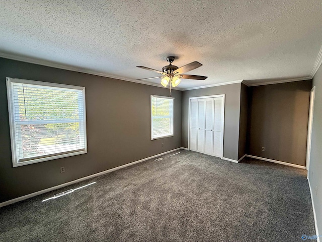 unfurnished bedroom featuring carpet floors, a closet, crown molding, baseboards, and a textured ceiling