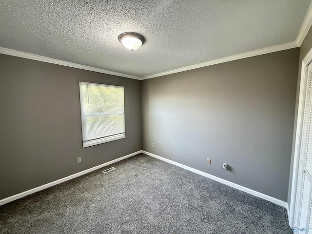 spare room with dark carpet, baseboards, crown molding, and visible vents