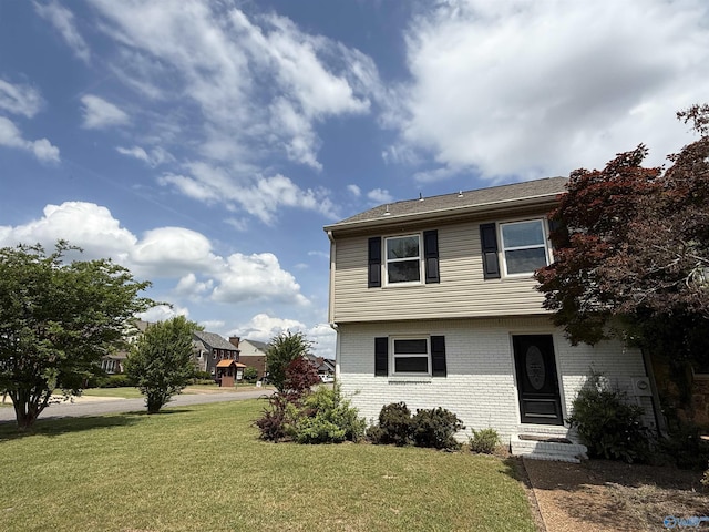 colonial home with a front lawn, brick siding, and entry steps