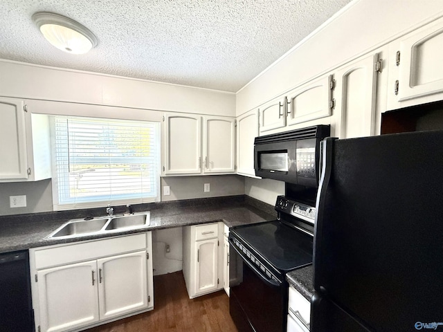 kitchen featuring dark countertops, a textured ceiling, a sink, and black appliances