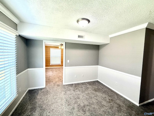 carpeted empty room featuring visible vents, baseboards, a textured ceiling, and ceiling fan