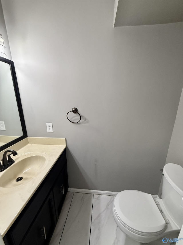 bathroom with baseboards, marble finish floor, vanity, and toilet