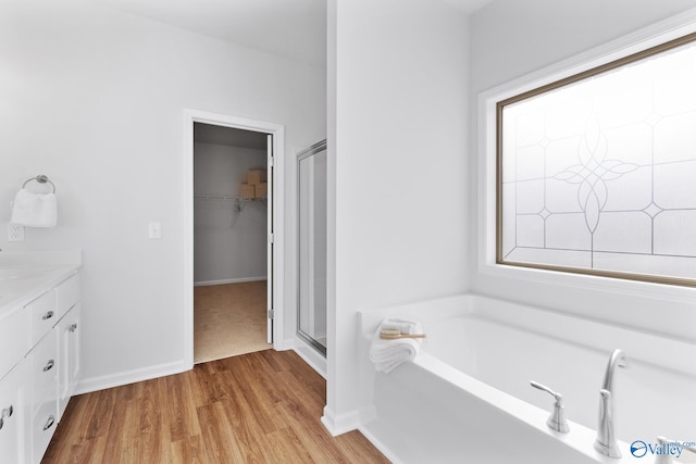 bathroom featuring hardwood / wood-style floors, vanity, and separate shower and tub