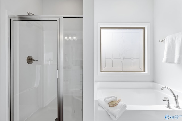 bathroom featuring shower with separate bathtub