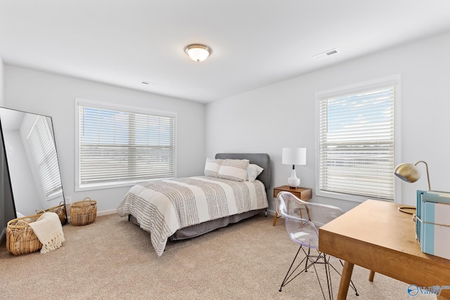 bedroom featuring light carpet and multiple windows