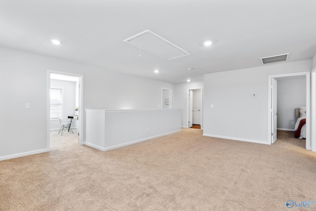 unfurnished room featuring attic access, light colored carpet, visible vents, and recessed lighting