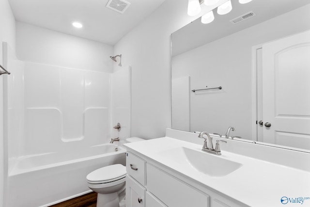 bathroom featuring toilet, vanity, visible vents, and bathing tub / shower combination