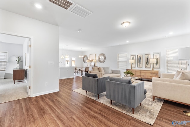 carpeted living room with sink and a notable chandelier