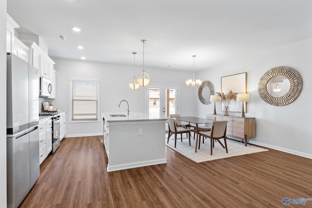 kitchen featuring dark hardwood / wood-style floors, a kitchen island with sink, white cabinetry, sink, and stainless steel appliances