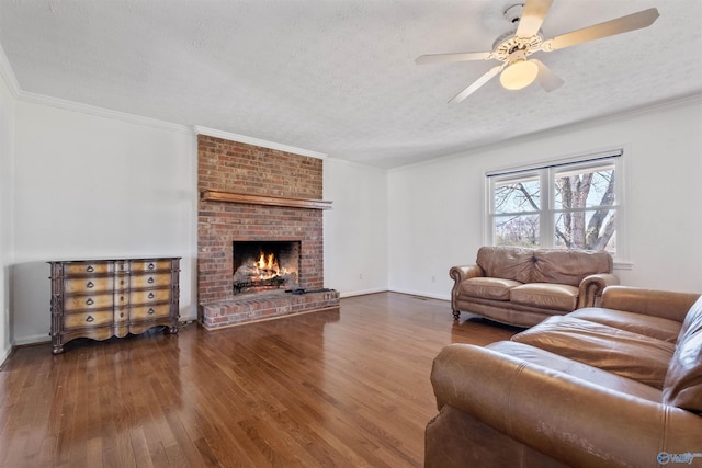 living area featuring a textured ceiling, wood finished floors, a fireplace, and ornamental molding